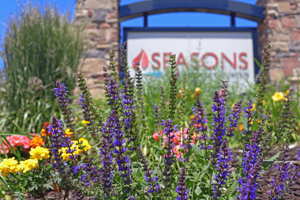 Flowers in front of Seasons sign